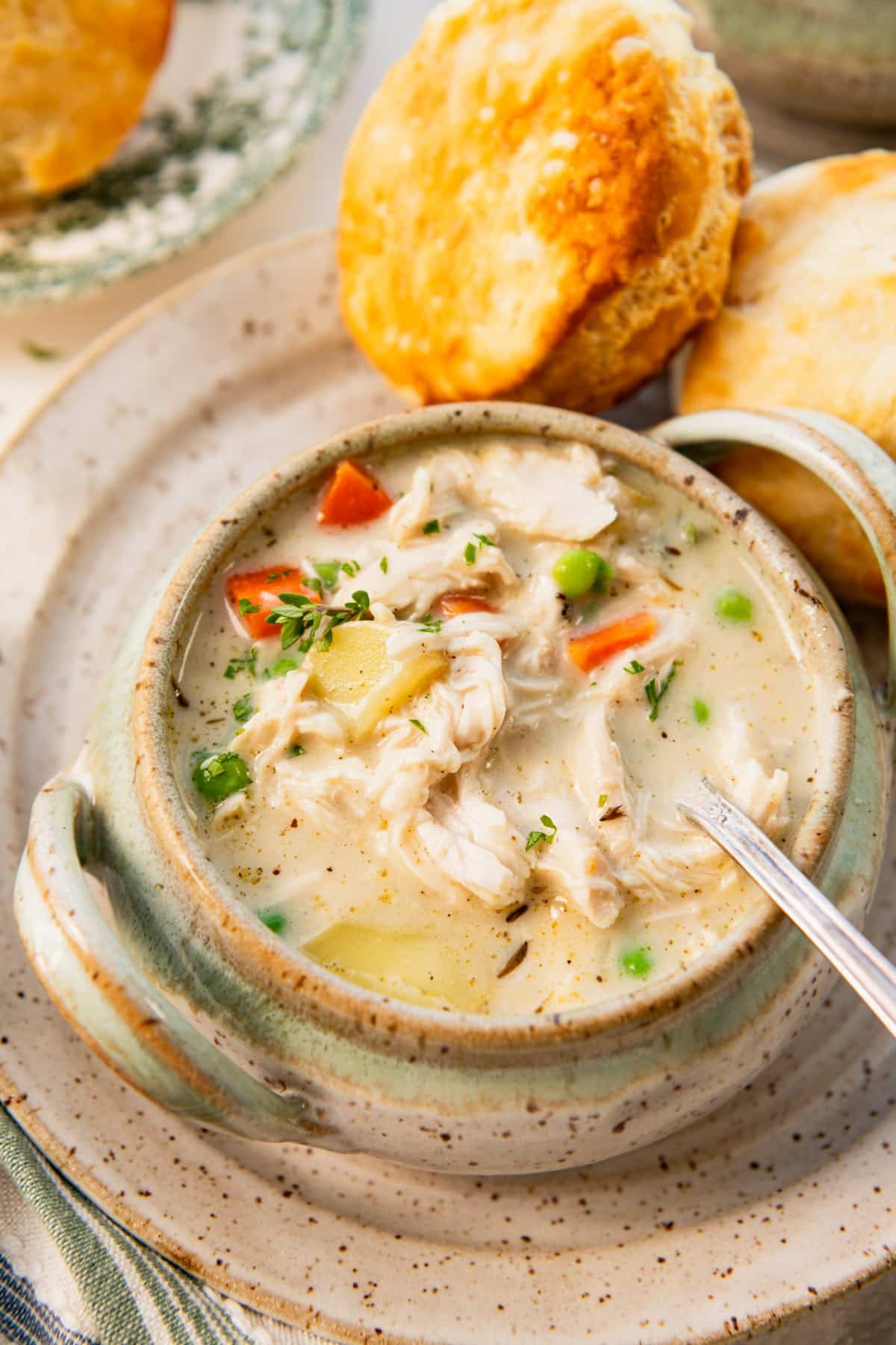 Side chicken pot pie soup with biscuits on the side.
