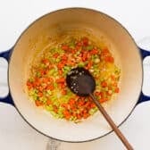Adding the garlic to the softened vegetables.