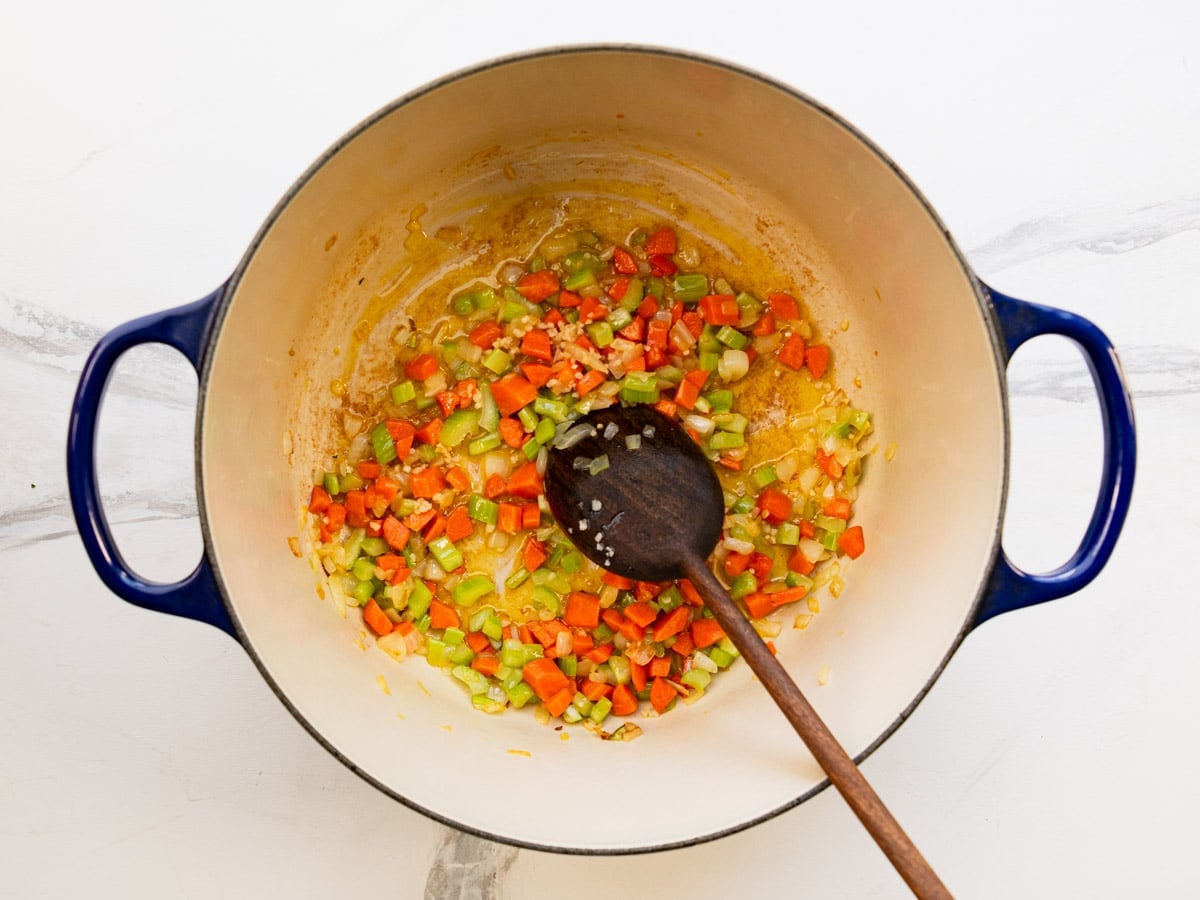 Adding the garlic to the softened vegetables.