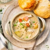 Horizontal overhead chicken pot pie soup with biscuits on the side.