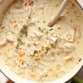 Horizontal overhead image of creamy chicken and wild rice soup in a Dutch oven.