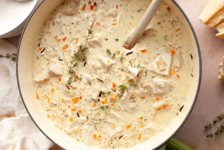 Horizontal overhead image of creamy chicken and wild rice soup in a Dutch oven.