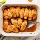 Horizontal overhead shot of a white baking dish full of baked crescent roll apple dumplings.