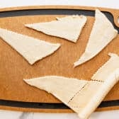 Separating crescent roll dough into triangles.