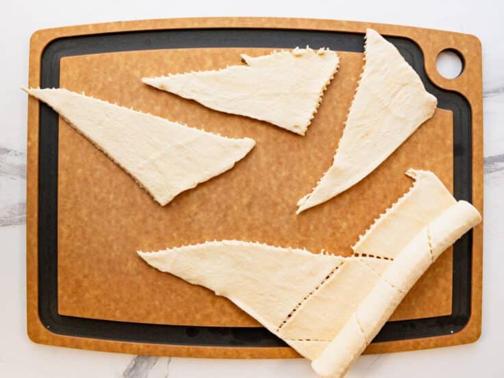 Separating crescent roll dough into triangles.