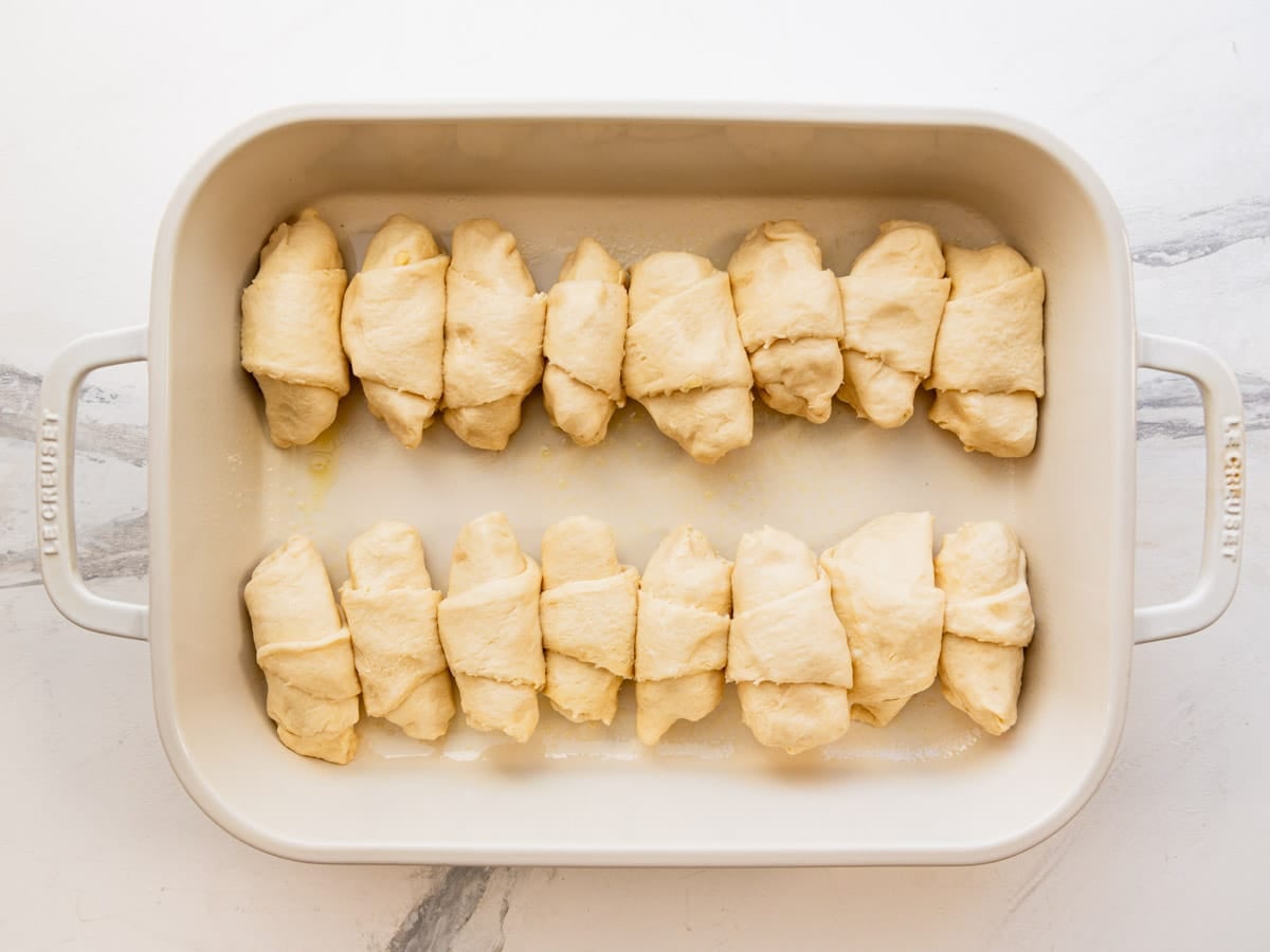 Arranging the apple dumplings in the baking dish.