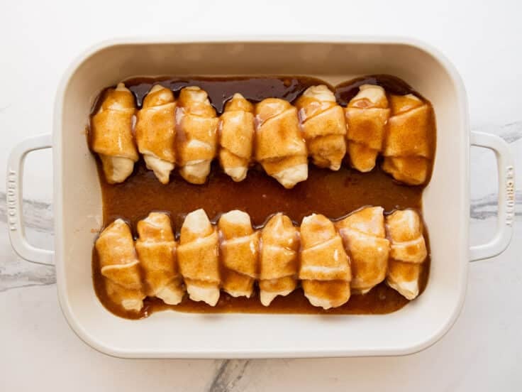 Pouring the brown sugar and butter mixture over the crescent rolls.