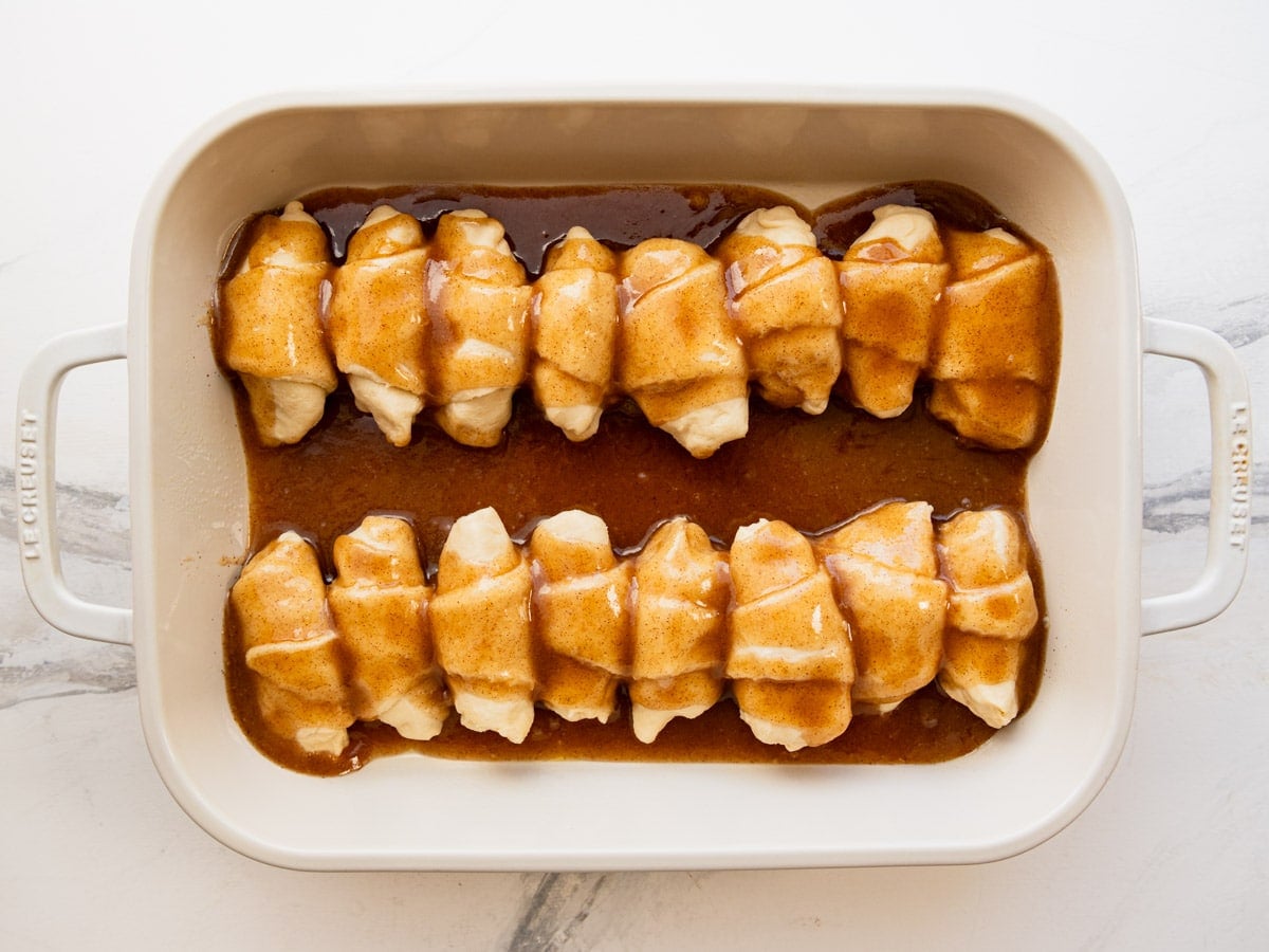 Pouring the brown sugar and butter mixture over the crescent rolls.