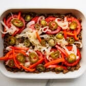 Adding jalapenos to the dish.