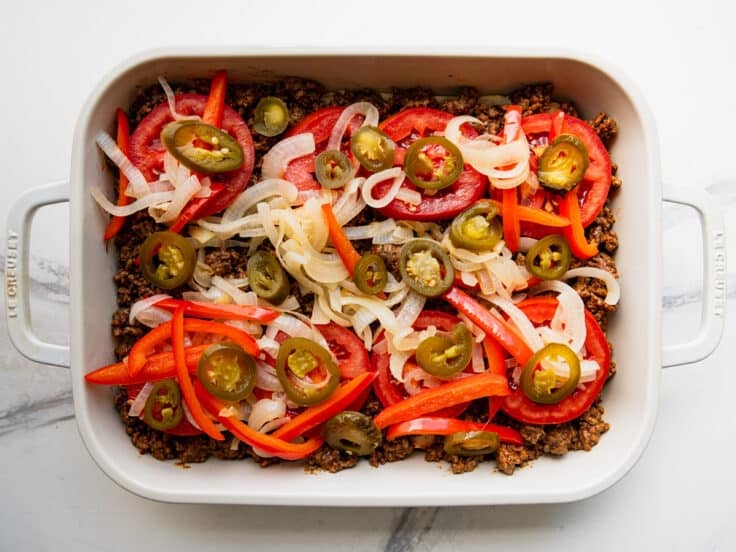 Adding jalapenos to the dish.