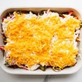 Adding the cheese to the top of a John Wayne casserole before it goes in the oven.