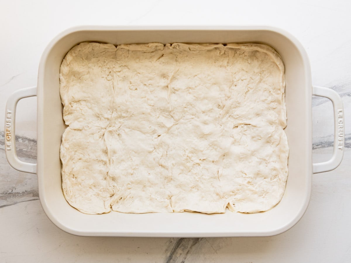 Biscuit dough spread in the bottom of the baking dish.