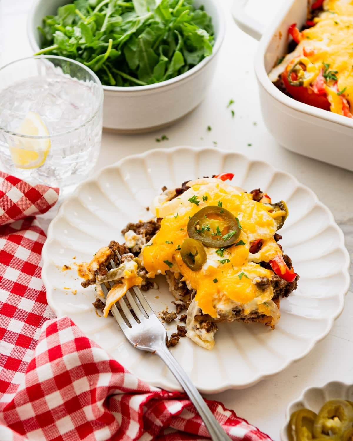 Side shot of a slice of John Wayne casserole on a white plate.