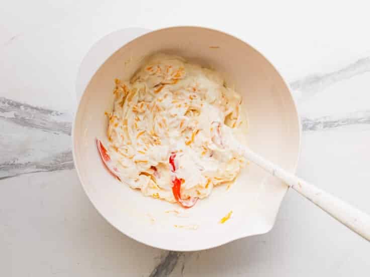 Stirring together the creamy mixture in a bowl.