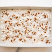Sprinkling pecans on top of the cake mix.