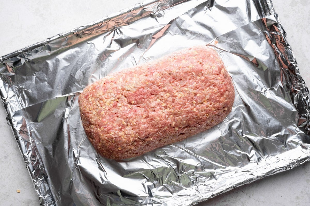 Meat mixture shaped into a loaf on the foil lined sheet pan.