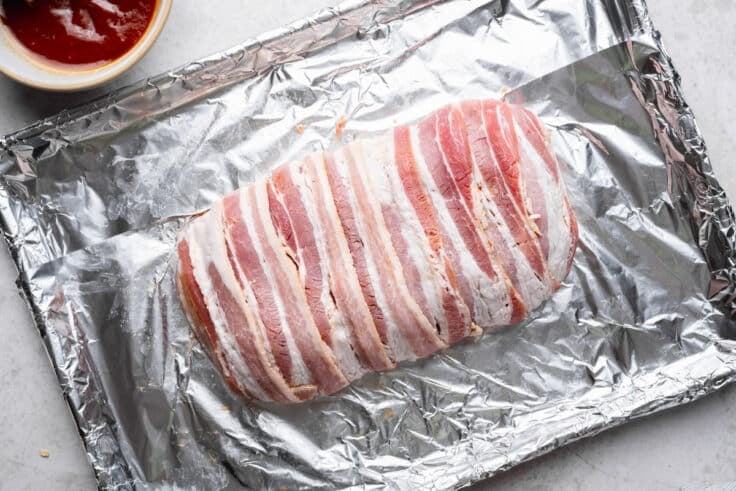Meatloaf wrapped in bacon before it goes in the oven.