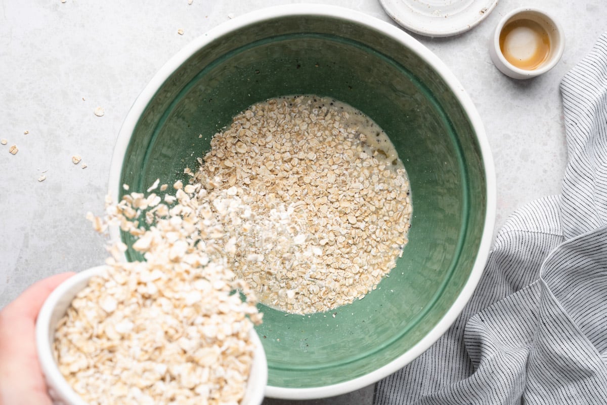 Adding oats to the bowl to soak.